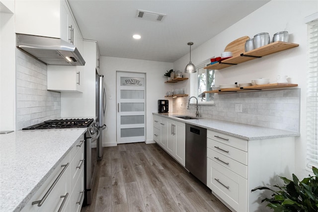 kitchen featuring stainless steel appliances, backsplash, white cabinetry, and sink