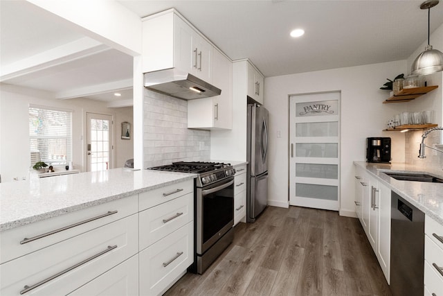 kitchen featuring pendant lighting, white cabinetry, stainless steel appliances, decorative backsplash, and sink