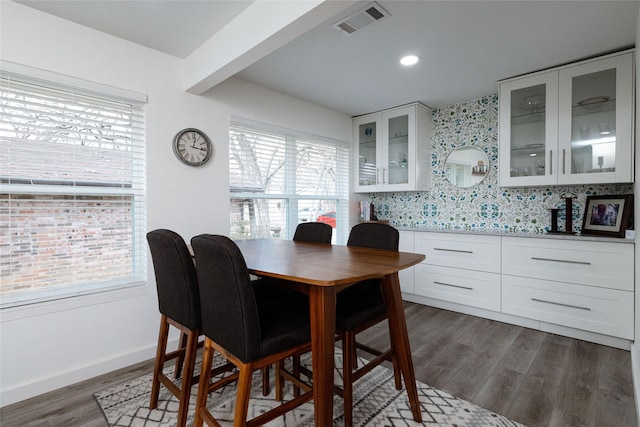 dining room with dark hardwood / wood-style floors and beamed ceiling