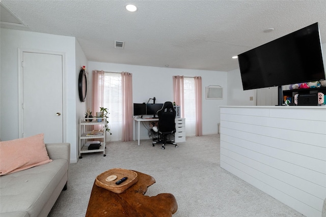 carpeted living room featuring a textured ceiling