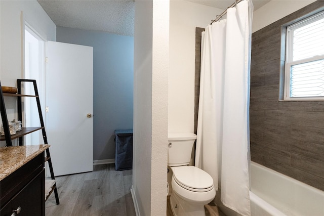 full bathroom with hardwood / wood-style floors, a textured ceiling, vanity, toilet, and shower / bath combo with shower curtain