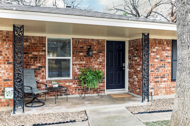 view of exterior entry featuring covered porch