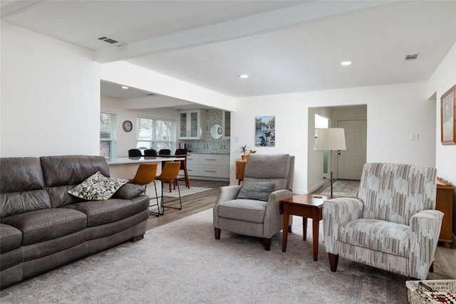 living room with light hardwood / wood-style floors and beamed ceiling