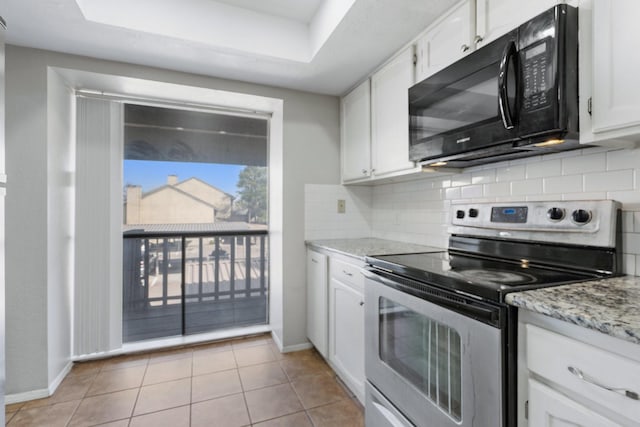 kitchen featuring light stone countertops, electric range, white cabinets, and light tile patterned flooring