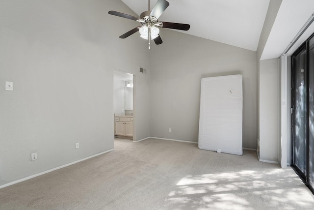 unfurnished bedroom featuring ceiling fan, connected bathroom, light colored carpet, and high vaulted ceiling