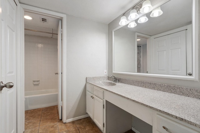 bathroom with tile patterned floors, tiled shower / bath combo, and vanity