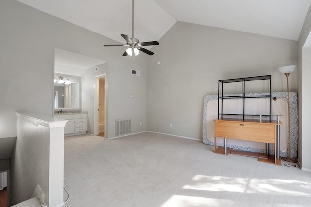 bedroom featuring ensuite bathroom, ceiling fan, high vaulted ceiling, sink, and light carpet