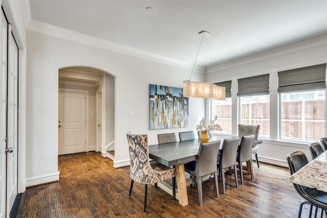 dining space with dark wood-type flooring and ornamental molding