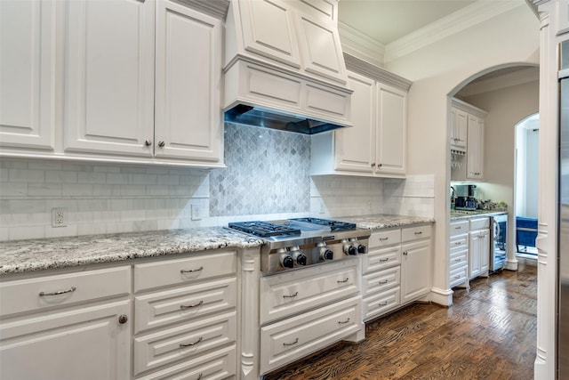 kitchen featuring stainless steel gas stovetop, decorative backsplash, dark wood-type flooring, ornamental molding, and white cabinets