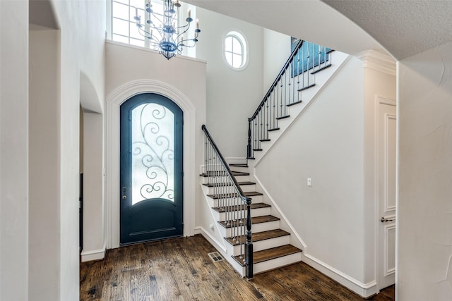 entrance foyer with dark wood-type flooring and a chandelier