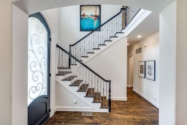 entrance foyer featuring dark wood-type flooring and crown molding