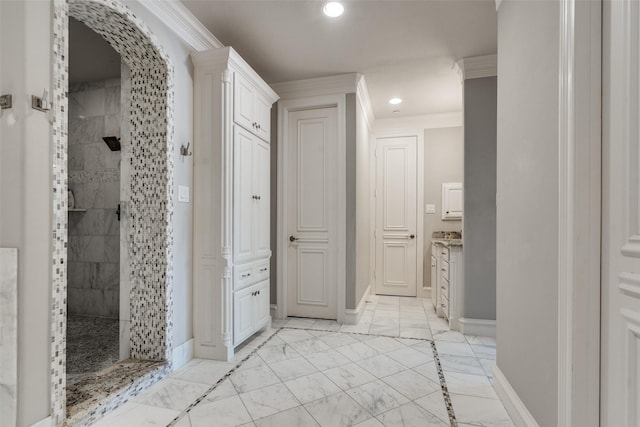 bathroom featuring ornamental molding, vanity, and a tile shower