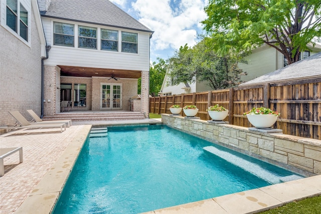 view of swimming pool featuring ceiling fan, french doors, and a patio