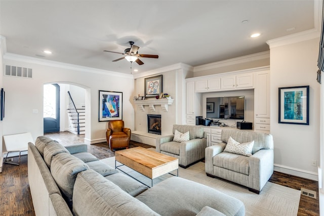 living room featuring ceiling fan, ornamental molding, and hardwood / wood-style floors