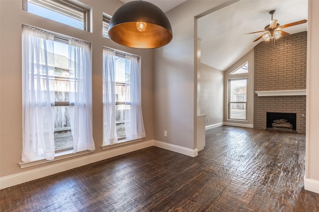 unfurnished living room with ceiling fan, a brick fireplace, and lofted ceiling