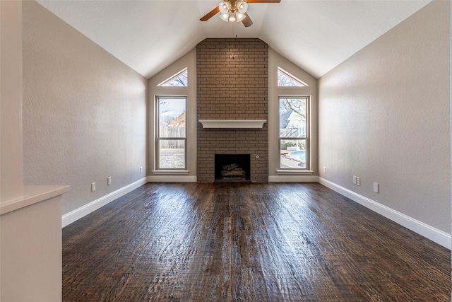 unfurnished living room featuring ceiling fan, vaulted ceiling, a brick fireplace, and dark hardwood / wood-style floors