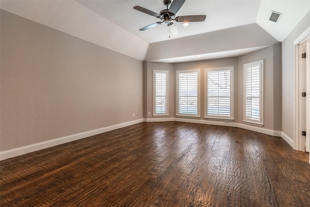 empty room featuring ceiling fan, vaulted ceiling, and dark hardwood / wood-style flooring