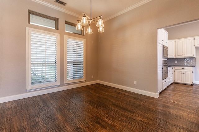 unfurnished dining area with dark hardwood / wood-style floors, crown molding, and a notable chandelier