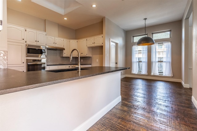 kitchen with tasteful backsplash, sink, stainless steel appliances, and white cabinetry