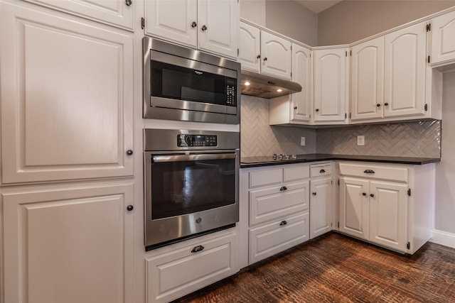 kitchen with stainless steel microwave, backsplash, dark wood-type flooring, white cabinets, and black electric cooktop