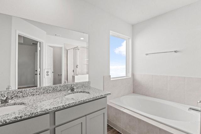 bathroom with hardwood / wood-style flooring, vanity, and separate shower and tub