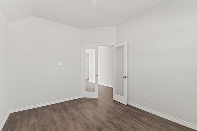 empty room with french doors, dark hardwood / wood-style flooring, and vaulted ceiling