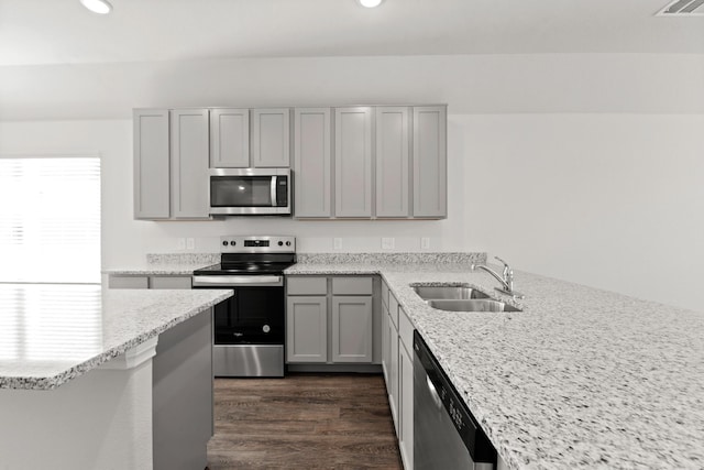 kitchen with light stone countertops, stainless steel appliances, gray cabinetry, and sink