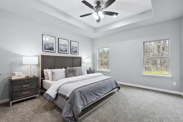 bedroom with ceiling fan, carpet, and a raised ceiling