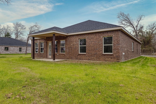 rear view of property with a lawn and a patio