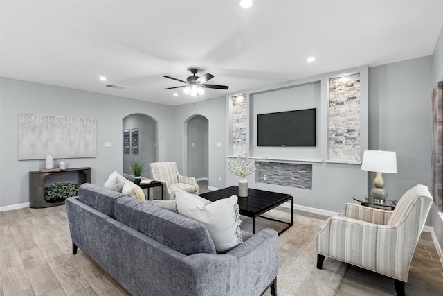 living area featuring recessed lighting, arched walkways, baseboards, and visible vents