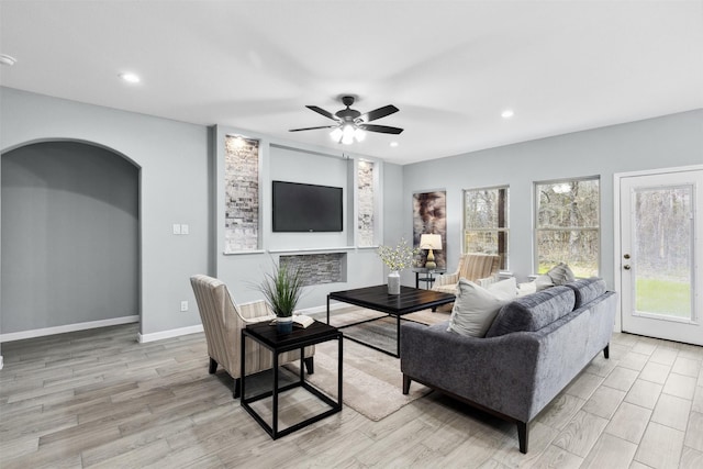 living room featuring recessed lighting, a ceiling fan, light wood-style flooring, and baseboards