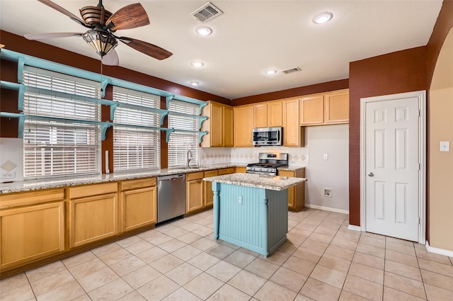 kitchen with a kitchen island, decorative backsplash, light tile patterned flooring, light stone countertops, and stainless steel appliances