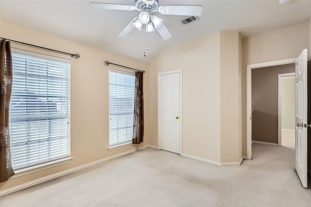 unfurnished bedroom featuring ceiling fan, lofted ceiling, and light colored carpet