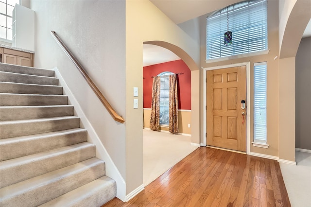 entryway with a high ceiling, light hardwood / wood-style flooring, and a healthy amount of sunlight