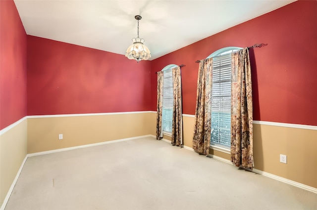 unfurnished room with an inviting chandelier