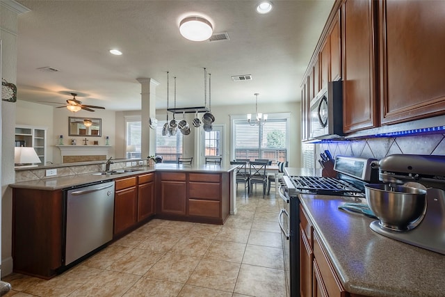 kitchen with stainless steel appliances, ceiling fan, a sink, tasteful backsplash, and dark countertops