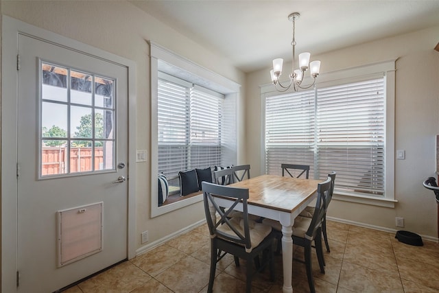 dining space with a chandelier, baseboards, and light tile patterned floors
