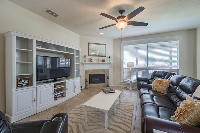 living area featuring light tile patterned floors, a ceiling fan, a tile fireplace, and recessed lighting