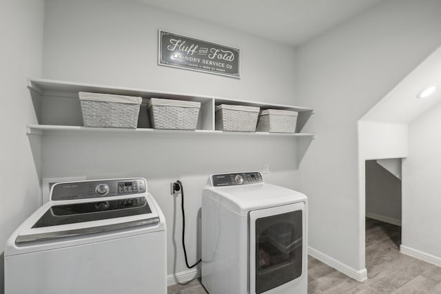 washroom featuring light hardwood / wood-style floors and washing machine and clothes dryer