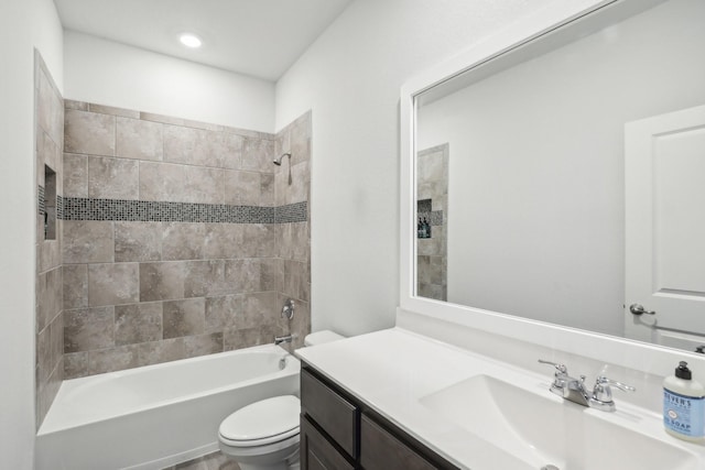 full bathroom with tiled shower / bath combo, vanity, and toilet