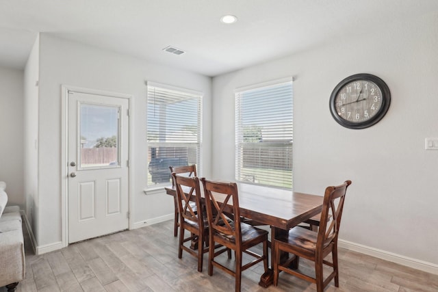 dining space with light hardwood / wood-style flooring and a healthy amount of sunlight