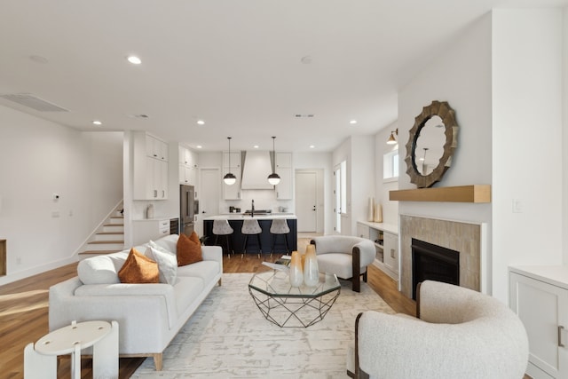 living room with light hardwood / wood-style floors and a tile fireplace