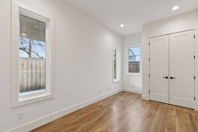 unfurnished bedroom featuring light hardwood / wood-style flooring and a closet