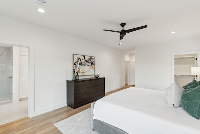 bedroom featuring ceiling fan, light hardwood / wood-style flooring, and ensuite bath