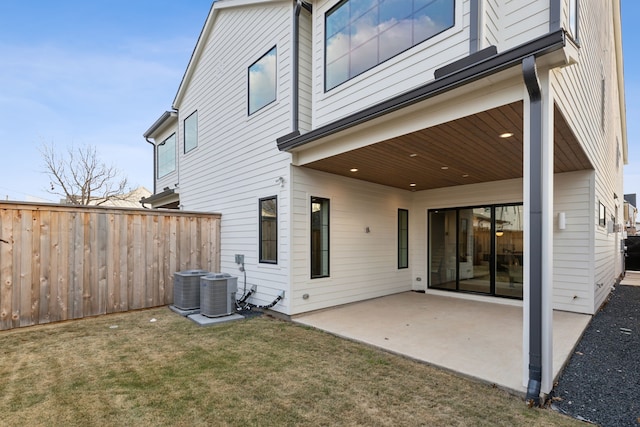 back of property featuring a lawn, central AC, and a patio