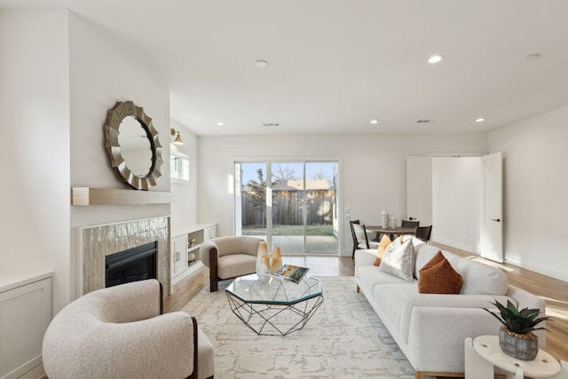 living room featuring light wood-type flooring and a fireplace