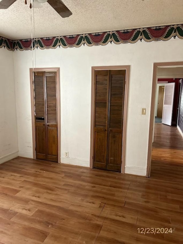 unfurnished bedroom with ceiling fan, wood-type flooring, and a textured ceiling