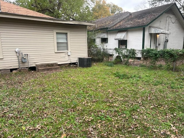 exterior space featuring central air condition unit and a yard