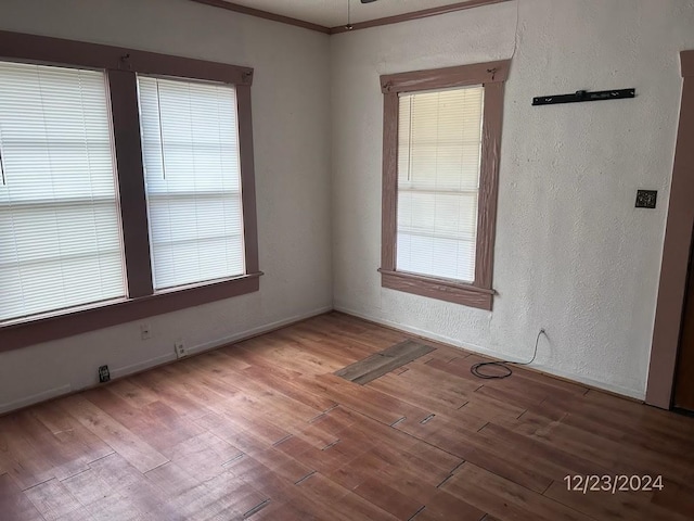 unfurnished room with light wood-type flooring and ornamental molding