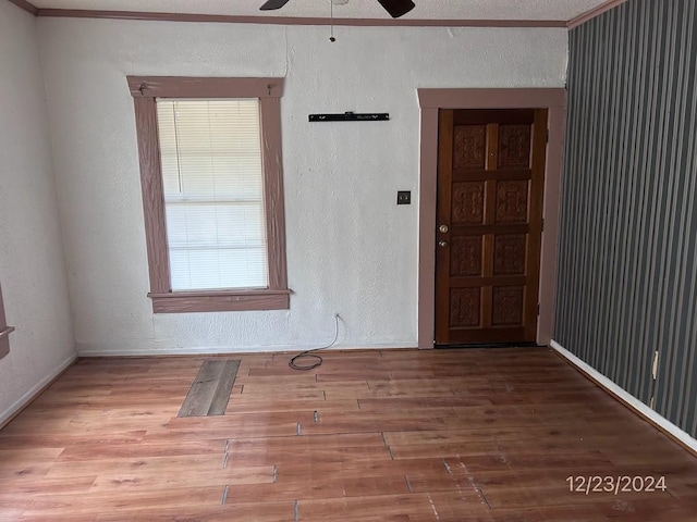 unfurnished room featuring a textured ceiling, ceiling fan, ornamental molding, and hardwood / wood-style floors